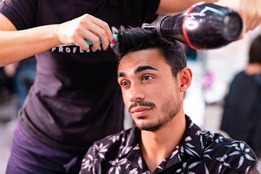 Professional hairdresser is cutting men's hair in beauty salon. photo