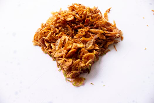 bawang goreng or Pile of fried Indonesian Deep Onion fries or shallots with circle shape isolated on white background. photo