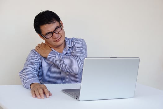 Asian man feels hurt his neck and shoulder during working on laptop computer for long time. Concept , Office syndrome. Health problem. Self massage to relief. Hard working photo