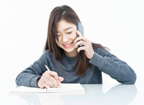 Woman using mobile phone and  writing notebook photo
