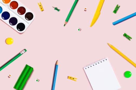 Pink background with writing materials. photo