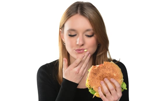 portrait of a beautiful funny young girl eating hamburger. photo