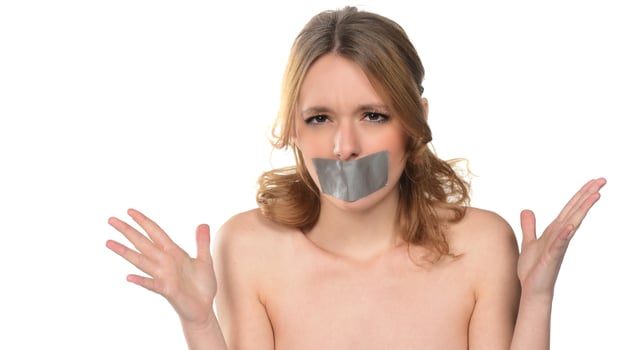scared young woman with tape over her mouth. photo