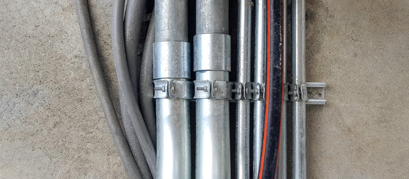 Stainless steel, gray or grey rubber pipeline installed on wall or floor background with copy space in industrial. Pipe protect electrical,  communication wire inside and transport gas or water. photo