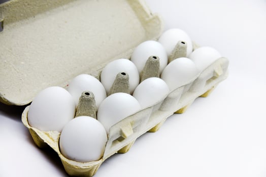 Fresh white chicken eggs in a paper bag. White eggs in a package on a white background. Eggs from the store. photo