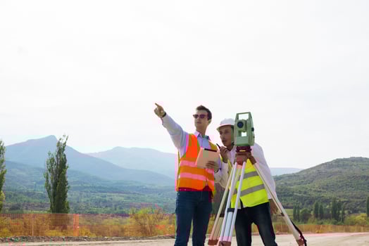 Surveyor engineer is measuring level on construction site. Surveyors ensure precise measurements before undertaking large construction projects. photo