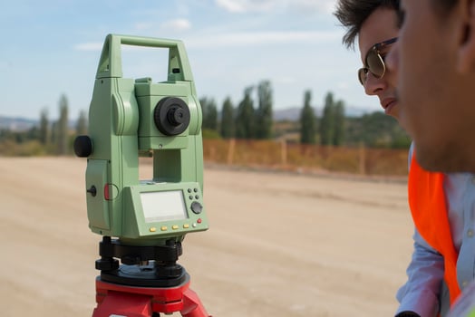 Surveyor engineer is measuring level on construction site. Surveyors ensure precise measurements before undertaking large construction projects. photo