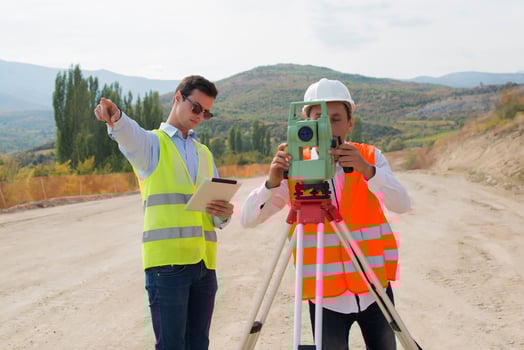 Surveyor engineer is measuring level on construction site. Surveyors ensure precise measurements before undertaking large construction projects. photo