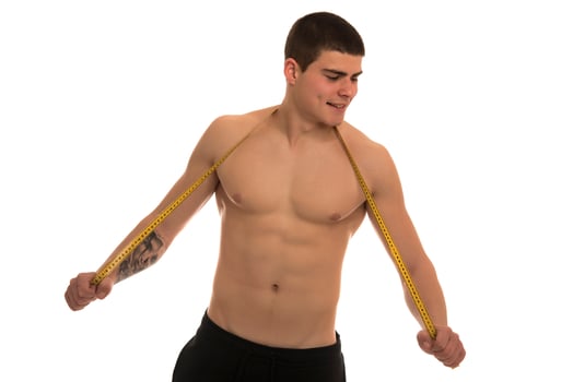male model with great body measuring his body with measuring tape photo