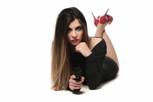 beautiful female with red high hills holding a gun. isolated photo