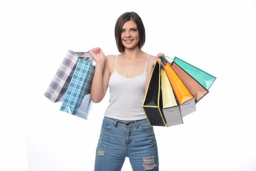 Image of a beautiful young brunette lady posing with shopping bags and looking at camera. shopping concept. Isolated photo