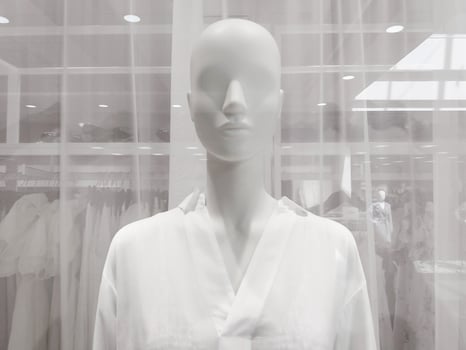 White female mannequin in clothing store window, closeup photo