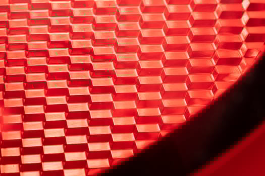 red background - detail of a red traffic warning lamp. The brake light assembly of a modern automobile photo