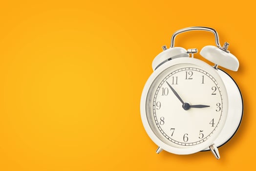 White vintage alarm clock on a yellow background photo