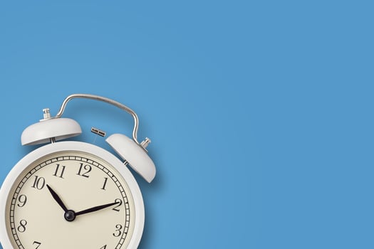 White vintage alarm clock on a blue background photo