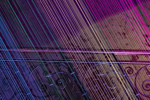 A flight of stairs with stretched threads illuminated with all the colors of the rainbow. Neon light, abstract photo