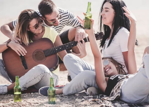 summer, holidays, vacation, music, happy people concept - group of friends with guitar having fun on the beach photo