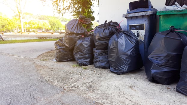 Black plastic garbage bags on the ground waiting for recycle photo