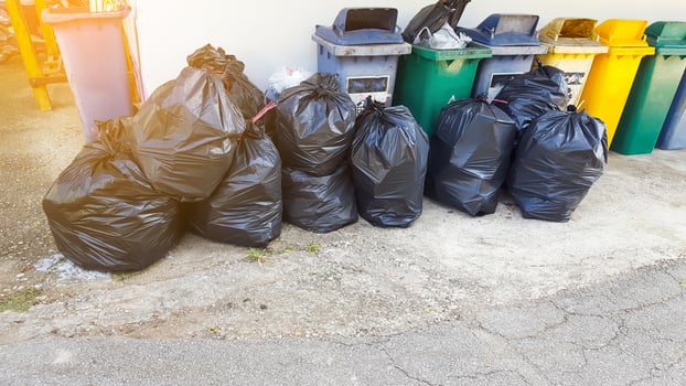 Black plastic garbage bags on the ground waiting for recycle photo