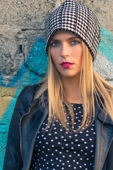 Portrait of casual blond girl leaning against a wall photo