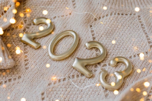 Numbers 2023 made of golden number on beige knitted sweater as background. Happy New Year 2022, Christmas, cozy holiday concepts. photo