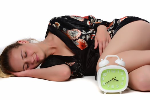 Happy young woman holding clock over isolated white background photo