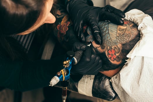 close up tattoo machine.  Woman creating picture on hand with it in salon photo