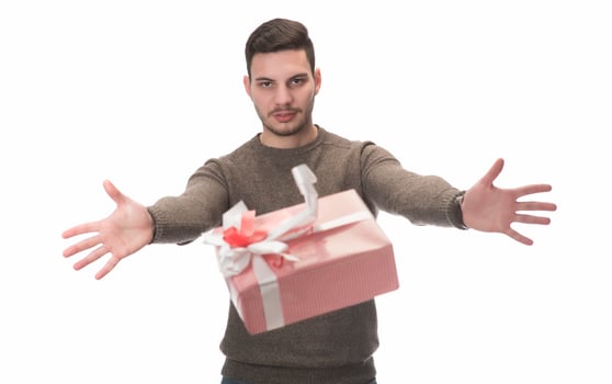 Young handsome man holding birthday present, looking positive and happy standing and smiling with a confident smile photo