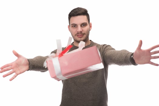 Young handsome man holding birthday present, looking positive and happy standing and smiling with a confident smile photo