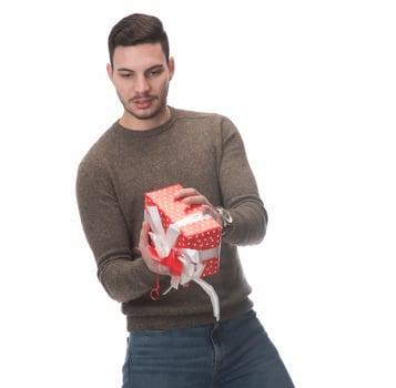 Young handsome man holding birthday present, looking positive and happy standing and smiling with a confident smile photo