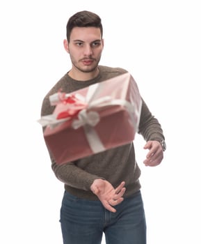 Young handsome man holding birthday present, looking positive and happy standing and smiling with a confident smile photo