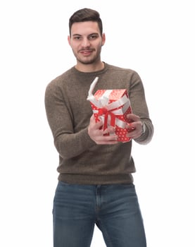 Young handsome man holding birthday present, looking positive and happy standing and smiling with a confident smile photo