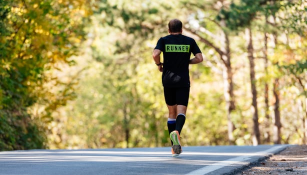 back view of sporty man runner running on mountain plateau in summer photo