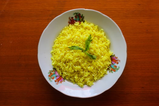 yellow rice or turmeric rice or nasi kuning is food made from rice cooked with turmeric, coconut milk and spices. so the taste is more savory photo