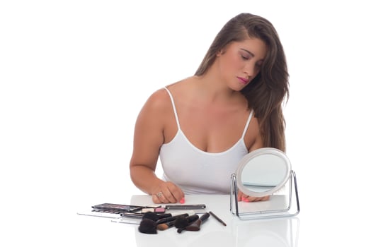 young woman checks her face skin in the mirror photo