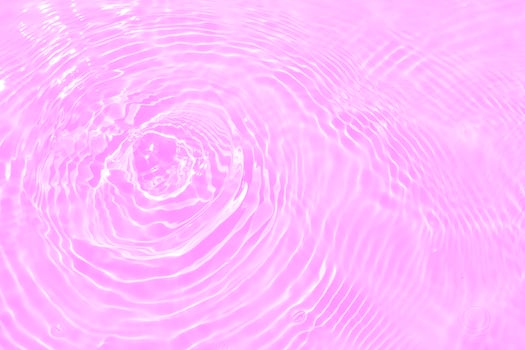 Defocus blurred transparent purple colored clear calm water surface texture with splashes and bubbles. Trendy abstract nature background. Water waves in sunlight with copy space. Pink water drop shine photo