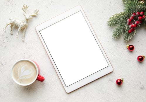 Christmas decorations and tablet on white concrete background. photo