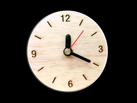 Wooden wall clock isolate on black background. photo