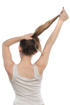 Female model arranging her hair. Woman tying hair in a bun. photo