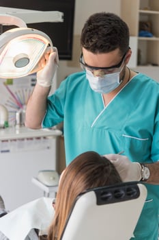 dentist curing patient's teeth filling cavity. Dentist working with professional equipment in clinic. photo