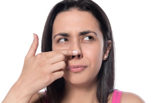 profile of young happy woman touches her nose with her finger on a white background photo