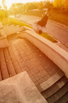 A young guy performs a side flip in the autumn park. The athlete practices parkour, training in street conditions. The concept of sports subcultures among youth photo