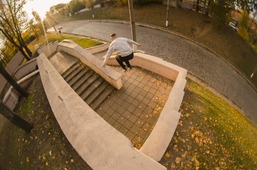 A young guy performs a jump through the space between the concrete parapets. The athlete practices parkour, training in street conditions. The concept of sports subcultures among youth photo
