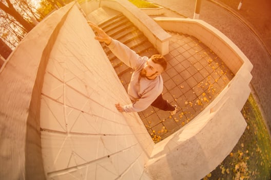 A young guy overcomes obstacles, climbing on concrete walls. The athlete practices parkour, training in street conditions. The concept of sports subcultures among youth photo