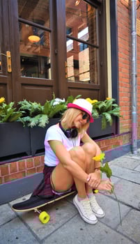 Beautiful hipster girl with skate board wearing sunglasses in the city. photo