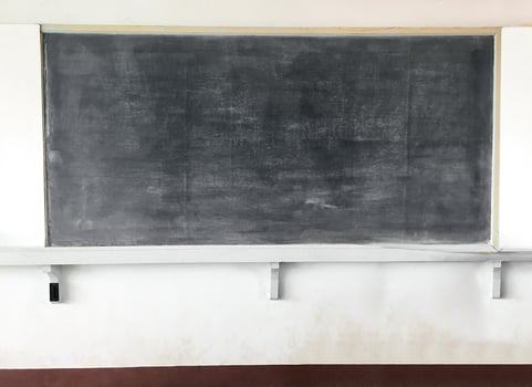 A blackboard for chalk are mounted on a white cement wall in a school classroom in a poor country in Asia. photo