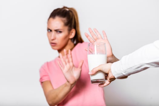 Woman feels bad, has an upset stomach, bloating due to lactose intolerance. Dairy intolerant person. Health care concept. Lactose intolerance and dairy products photo