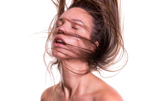 Portrait of a beautiful woman with a long hair. Young brunette model with beautiful hair - isolated on white background. Young girl with hair flying in the wind. photo