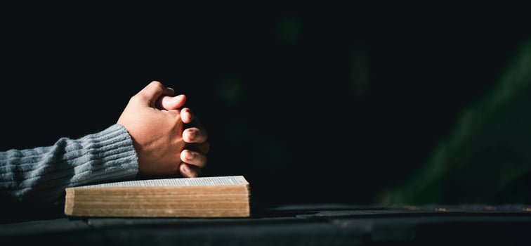 Prayer person hand in black background. Christian catholic woman are praying to god in dark at church. Girl believe and faith in jesus christ. Christ religion and christianity worship or pray concept. photo