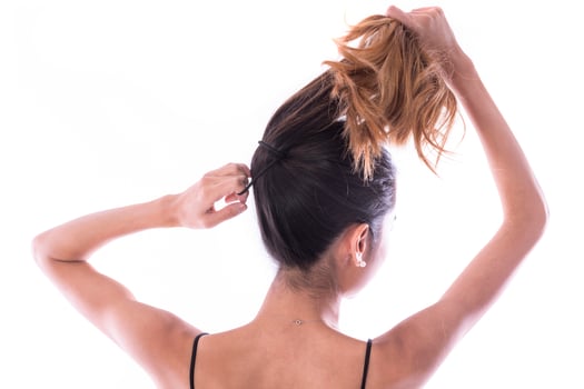 back view of young woman tied her hair in bun. isolated photo